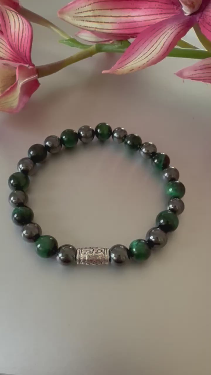Handmade men’s bracelet with deep green tiger eye and black-silver hematite beads, accented by an engraved silver-tone barrel 